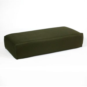 Può includere: Un cuscino o un guanciale rettangolare di colore verde scuro. Il cuscino è realizzato in un materiale morbido e in tessuto.