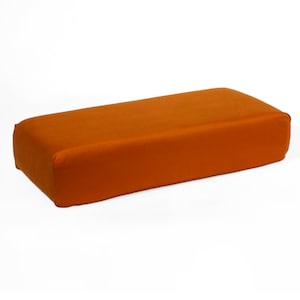 May include: A long, rectangular, orange-colored cushion or ottoman.