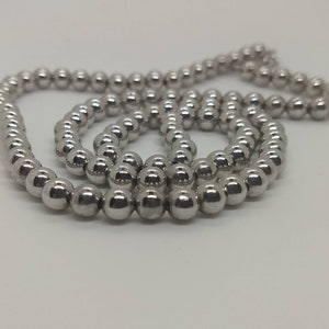 May include: A silver chain necklace made of round beads.