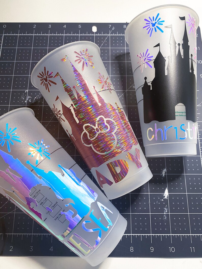 Puede incluir: Tres vasos de pl&aacute;stico transparente con acabado mate. Cada vaso tiene un dise&ntilde;o diferente con una silueta del castillo de Cenicienta con fuegos artificiales. Los vasos est&aacute;n personalizados con los nombres "Elsa", "Ady" y "Christina".