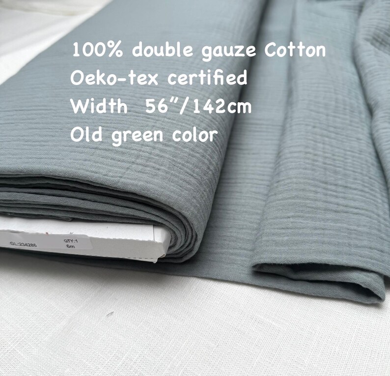 May include: A roll of old green double gauze cotton fabric. The fabric is 56 inches wide and Oeko-tex certified. The text on the image reads "100% double gauze Cotton", "Oeko-tex certified", "Width 56"/142cm", and "Old green color".