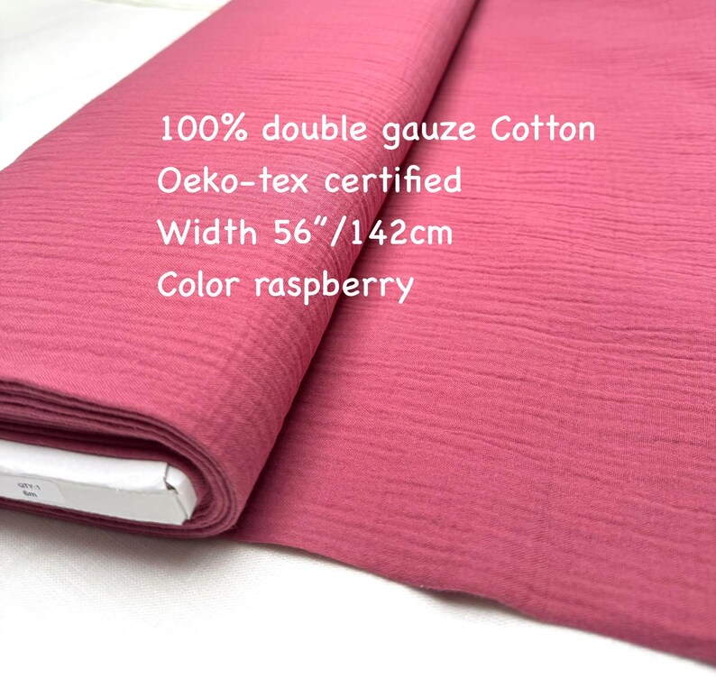 May include: A roll of raspberry-colored double gauze cotton fabric. The fabric is 56 inches wide and Oeko-Tex certified. The text on the image reads "100% double gauze Cotton", "Oeko-tex certified", "Width 56"/142cm", and "Color raspberry".