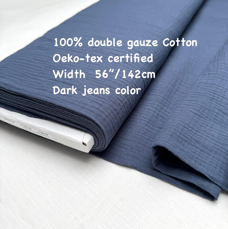 May include: A roll of dark jeans color 100% double gauze cotton fabric. The fabric is Oeko-tex certified and is 56 inches wide. The text on the fabric reads "100% double gauze Cotton", "Oeko-tex certified", "Width 56"/142cm", and "Dark jeans color".