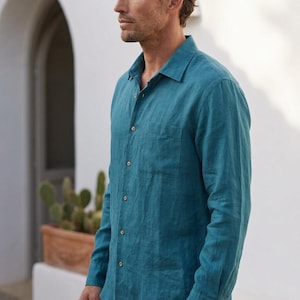 Peut inclure: Une chemise à manches longues boutonnée de couleur bleu sarcelle unie. La chemise présente un col classique, une poche poitrine unique sur le côté gauche et des boutons de couleur claire sur la patte de boutonnage. Le tissu a un tissage texturé.