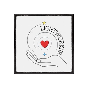 May include: Square patch with a black border and a white center. The design features a hand holding a red heart, with the word "LIGHTWORKER" in a circular pattern. A yellow star and blue diamond complete the design.