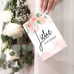 May include: A pink and white card with watercolor flowers and the text "Liebe f&uuml;r immer" in black script.
