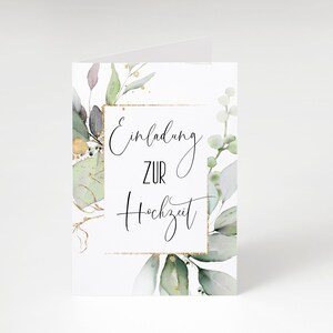 May include: A white card with a gold frame and green watercolor leaves. The text inside the frame reads "Einladung zur Hochzeit" which translates to "Invitation to the Wedding" in English.
