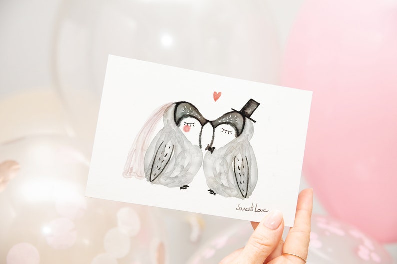 May include: A watercolor illustration of two owls wearing wedding attire. The owl on the left is wearing a veil and the owl on the right is wearing a top hat. The owls are kissing and there is a small red heart above them. The text "sweet love" is written below the owls.