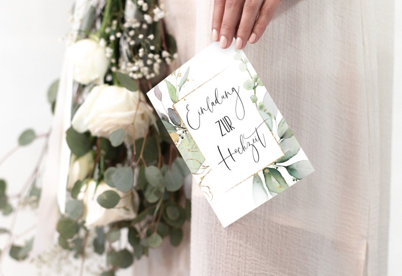 May include: A white card with gold lettering that says "Einladung zur Hochzeit" surrounded by green watercolor leaves.