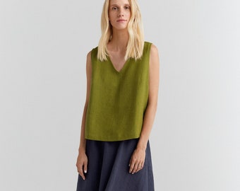 May include: An olive green sleeveless top with a V-neck, worn with a navy blue midi skirt. The outfit is finished with black sandals. The clothing looks to be made of linen or a similar natural fabric.