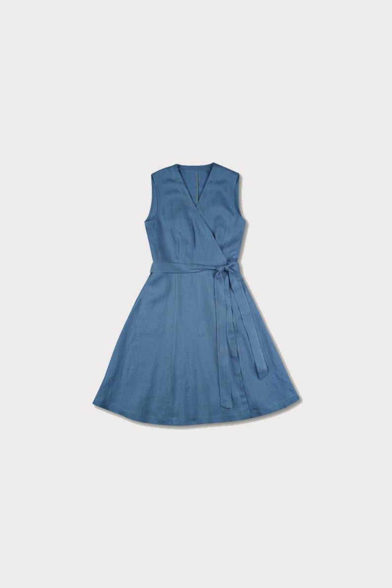 May include: A blue linen wrap dress with a V-neck and sleeveless design. The dress has a tie belt at the waist.