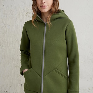 May include: Olive green hooded sweatshirt with a full-length zipper and front pockets. The sweatshirt has a gray zipper and a matching gray lining in the hood. The model is wearing blue jeans.