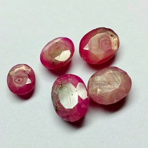 以下が含まれることがあります： 白い虹色の輝きを持つ、ファセットカットのピンクの楕円形の宝石が5つあります