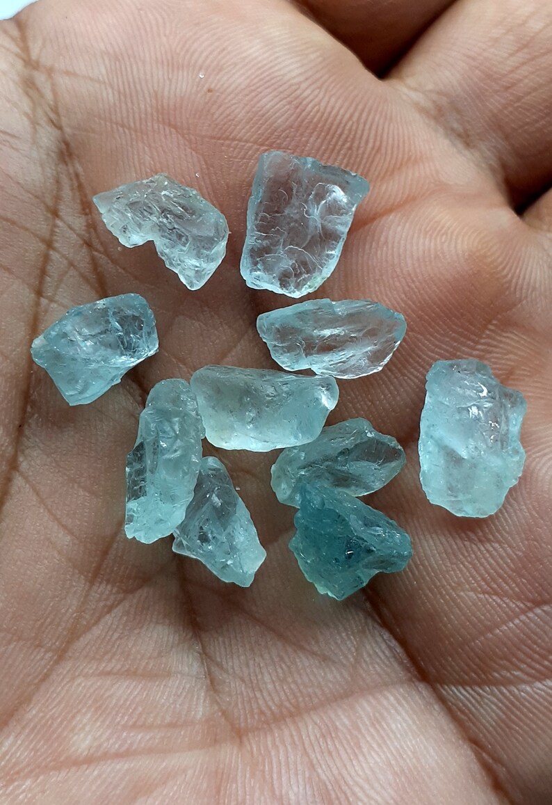 Puede incluir: Una colecci&oacute;n de diez peque&ntilde;os cristales de aguamarina azul claro de formas y tama&ntilde;os variados.