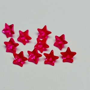 May include: A scattering of bright pink star-shaped beads, perfect for crafting or jewelry making.