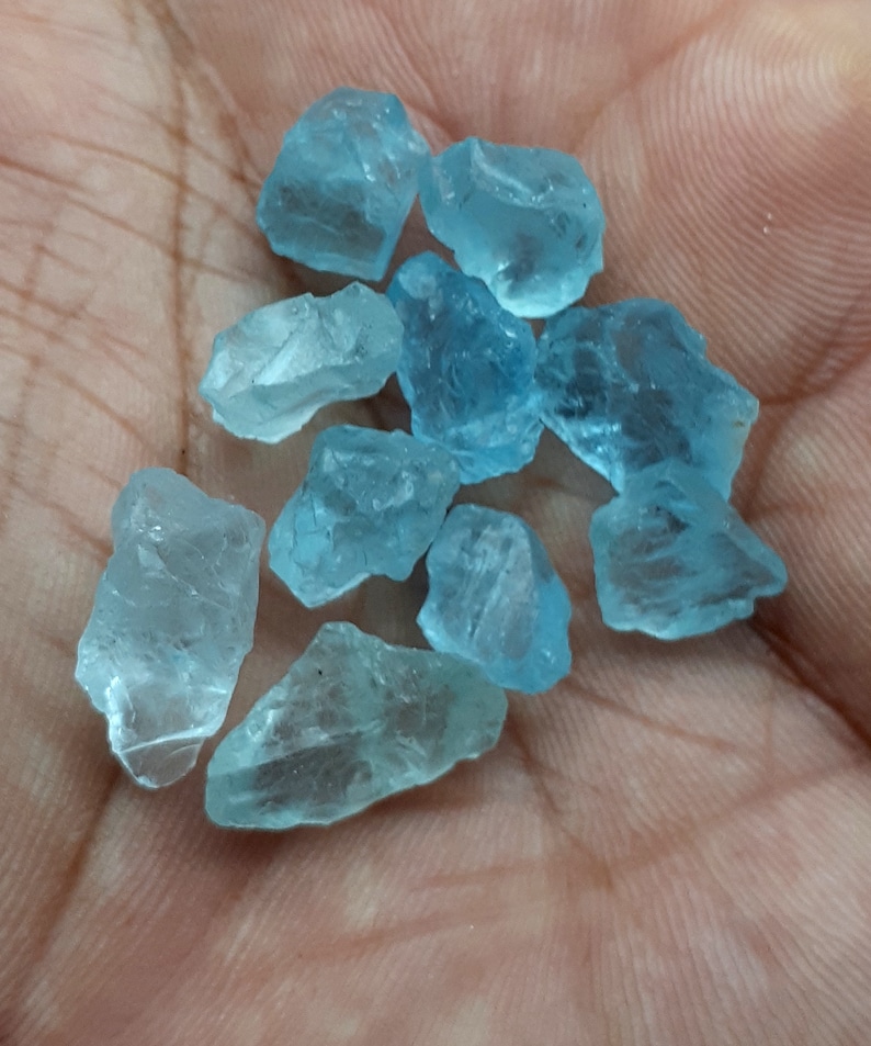 Puede incluir: Una colecci&oacute;n de diez peque&ntilde;os cristales de aguamarina azul claro. Los cristales son &aacute;speros y tienen un aspecto natural sin pulir.