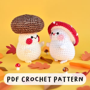 Może przedstawiać: Dwie szydełkowe figurki grzybów z uśmiechniętymi twarzami i różowymi policzkami. Jeden ma brązowy kapelusz, drugi czerwono-biały. Figurki są białe z małymi ramionami i nogami. Tekst "PDF CROCHET PATTERN" znajduje się na dole.