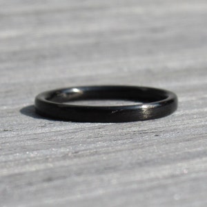 May include: A simple black ring with a smooth, polished finish.