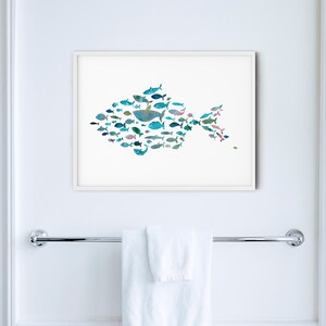 K&ouml;nnte beinhalten: Ein gerahmter Kunstdruck mit einem Fisch, der aus verschiedenen Illustrationen von blauen und t&uuml;rkisfarbenen Fischen besteht. Das Kunstwerk wird an einer wei&szlig;en Wand &uuml;ber einem Handtuchhalter aus Chrom mit einem gefalteten wei&szlig;en Handtuch gezeigt. Der Raum hat wei&szlig;e Fliesen und eine wei&szlig;e T&uuml;r.
