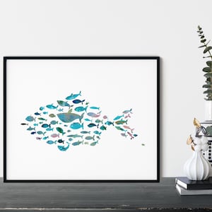 K&ouml;nnte beinhalten: Gerahmter Kunstdruck mit einem Fisch, der aus zahlreichen kleineren Fischen in Blau-, Gr&uuml;n- und Rosat&ouml;nen besteht. Das Kunstwerk ist vor einem wei&szlig;en Hintergrund und in Schwarz gerahmt. Der Druck wird auf einer dunklen Oberfl&auml;che pr&auml;sentiert.