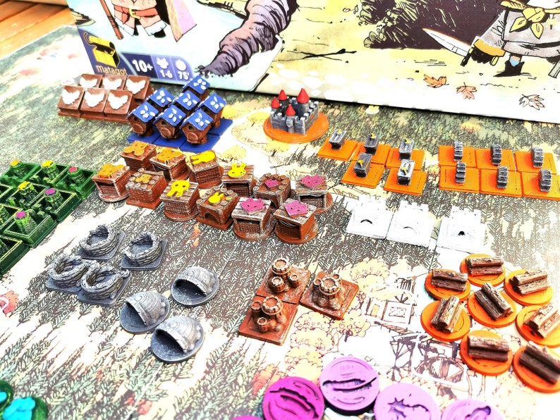 May include: A collection of colorful wooden game pieces, including houses, trees, and other structures. The pieces are arranged on a table with a brown background. The game pieces are made of wood and painted in various colors, including red, blue, green, yellow, and brown.