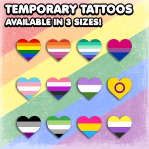 May include: Temporary tattoos in the shape of hearts, each featuring a different LGBTQ+ pride flag design. The image includes a rainbow background and the text "TEMPORARY TATTOOS AVAILABLE IN 3 SIZES!"