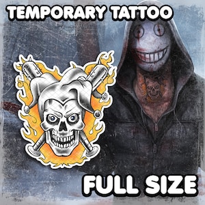 May include: Temporary tattoo featuring a skull with jester's hat and crossed baseball bats in flames. The skull has a black and white checkered pattern and is surrounded by yellow flames. The text "TEMPORARY TATTOO" is at the top of the image and "FULL SIZE" is at the bottom.