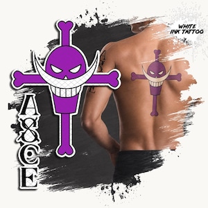Può includere: Un design per tatuaggio temporaneo raffigurante un teschio viola con grandi baffi bianchi e ossa incrociate, accompagnato dal testo verticale ASCE. Il design è mostrato applicato su una schiena, con il testo WHITE INK TATTOO visibile nell'angolo.
