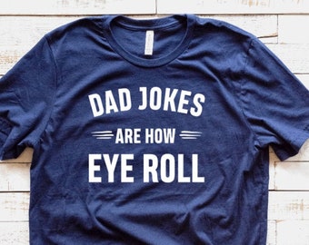 May include: A navy blue t-shirt with white text that reads "Dad Jokes Are How Eye Roll".