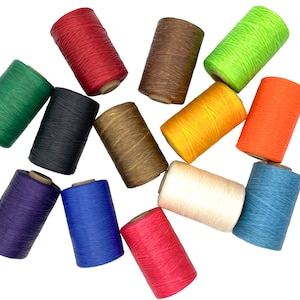 May include: A collection of thirteen cylindrical spools of waxed thread in a variety of vibrant colors including red, brown, lime green, dark green, black, tan, yellow, orange, purple, blue, pink, cream, and light blue, arranged in a scattered layout.