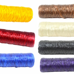 May include: A collection of seven cylindrical spools of raffia ribbon in various colors, including bright yellow, deep red, vibrant blue, dark brown, off-white, black, and deep purple, each featuring a woven, textured surface appearance.