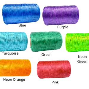 May include: Spools of colorful twine in blue, purple, turquoise, green, neon green, neon orange, and pink. Each spool has a label with its color name. The twine is tightly wound and appears to be made of a natural fiber.