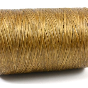 May include: A spool of golden-brown twine, tightly wound and textured. The twine is made of natural fibers, ideal for crafting, packaging, or decorative purposes. The spool is cylindrical and sits against a white background.
