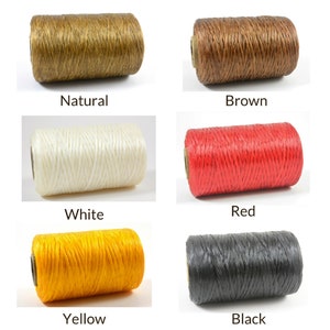 Pode incluir: Uma coleção de seis rolos de barbante em várias cores: natural, castanho, branco, vermelho, amarelo e preto. Cada rolo é rotulado com o seu nome de cor. O barbante é enrolado firmemente em um núcleo de papelão.