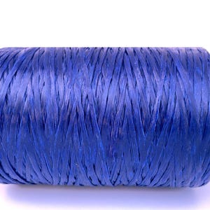 May include: A tightly wound spool of blue raffia ribbon. The ribbon is a vibrant shade of blue, with a textured, woven appearance. This craft supply is ideal for gift wrapping, floral arrangements, and other creative projects.