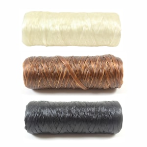 May include: Three spools of braided cord in cream, brown, and black. The cords are tightly woven, with a slightly glossy finish. The cream-colored spool is at the top, followed by the brown and then the black spool at the bottom.
