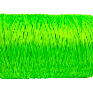 May include: A bright green spool of raffia ribbon, ideal for crafting and gift wrapping. The tightly wound material has a textured appearance and is set against a clean white background. This vibrant ribbon adds a pop of color.
