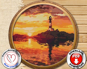 May include: A cross-stitch pattern of a lighthouse on a rocky island at sunset. The sky is a vibrant orange and yellow, with clouds in the background. The lighthouse is white with a red roof and a black lantern. The pattern is framed in a round, wooden frame.