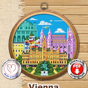 May include: A cross-stitch embroidery of Vienna, Austria, in a wooden hoop. The design features colorful buildings, a blue sky, and a statue. The text "Vienna Austria" is displayed below the hoop. Includes a "Made with love" logo and a "Download PDF" button.