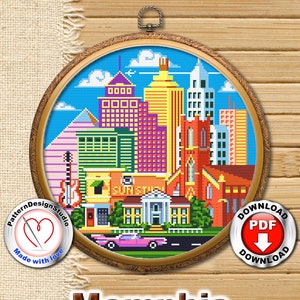 May include: Cross stitch pattern of the Memphis skyline, featuring a church, buildings, and a car. The pattern is in a round frame with a wooden background. The words "Memphis" and "Download PDF" are visible below the frame.