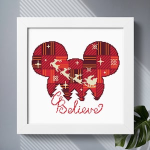 May include: Red and white cross-stitch pattern of a Mickey Mouse head with Santa Claus and reindeer flying in a sleigh. The text "Believe" is below the image.