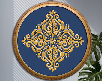 May include: A gold and blue embroidery hoop with a geometric pattern in the center. The pattern is a diamond shape with intricate swirls and lines.