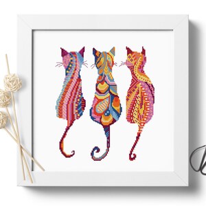 Pode incluir: Tr&ecirc;s gatos coloridos em uma moldura branca. Os gatos s&atilde;o estilizados e t&ecirc;m um padr&atilde;o geom&eacute;trico. Os gatos est&atilde;o olhando em dire&ccedil;&otilde;es diferentes. O fundo &eacute; branco.