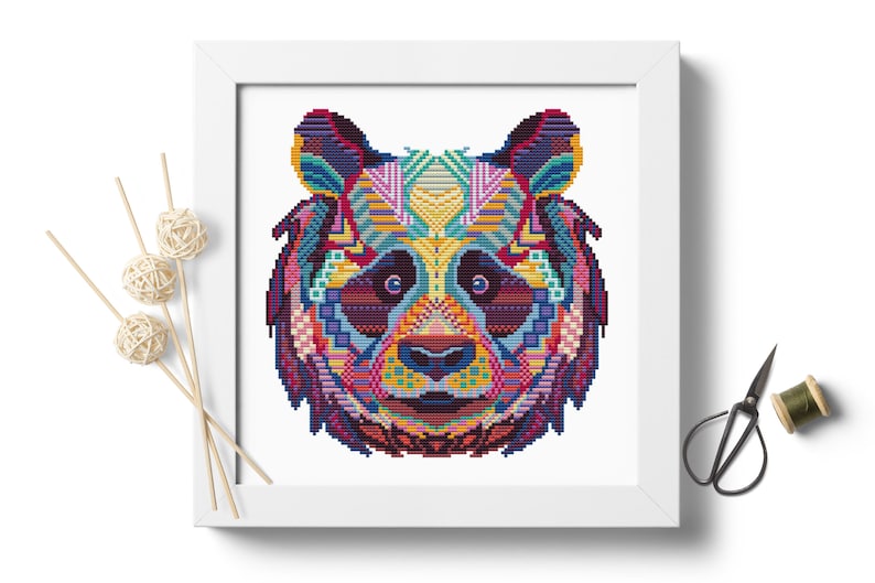 Pu&ograve; includere: Un design di orso panda geometrico e colorato su sfondo bianco. La pelliccia del panda &egrave; composta da varie forme e colori, tra cui blu, viola, rosa, giallo e verde.