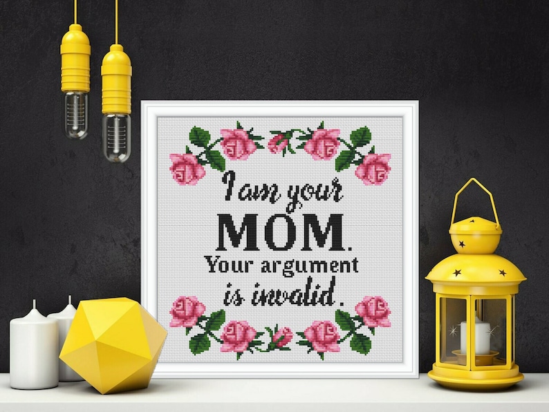 May include: White framed cross-stitch with pink roses and the text "I am your MOM. Your argument is invalid."