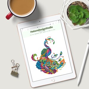 May include: A colourful, geometric peacock design on a white background. The peacock is made up of various shapes and colours, including blue, green, yellow, orange, and pink. The design is intricate and detailed, and it would be perfect for a cross-stitch or embroidery project.