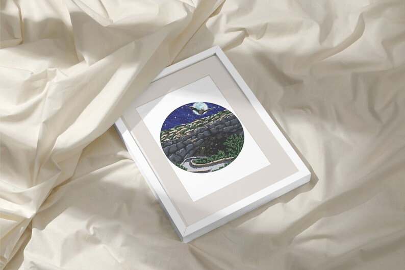 May include: A framed print of a circular illustration depicting a winding road leading into a cave under a full moon with a bat flying overhead. The sky is dark blue with white stars and the cave is made of gray stone.