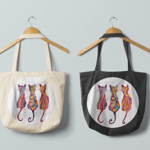 Pode incluir: Duas sacolas de compras com um design circular apresentando tr&ecirc;s gatos coloridos. A sacola &agrave; esquerda &eacute; branca e a sacola &agrave; direita &eacute; preta.