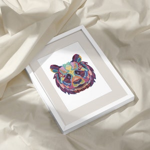 Pu&ograve; includere: Una stampa incorniciata di un panda astratto colorato su sfondo bianco. Il panda &egrave; composto da forme geometriche e motivi in ​​tinte di rosa, blu, verde, giallo e viola.