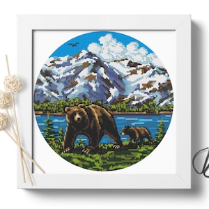Pu&ograve; includere: Un motivo di punto croce rotondo con un orso bruno e un cucciolo che camminano in un ambiente boschivo. Lo sfondo include un lago blu, alberi verdi e montagne innevate.